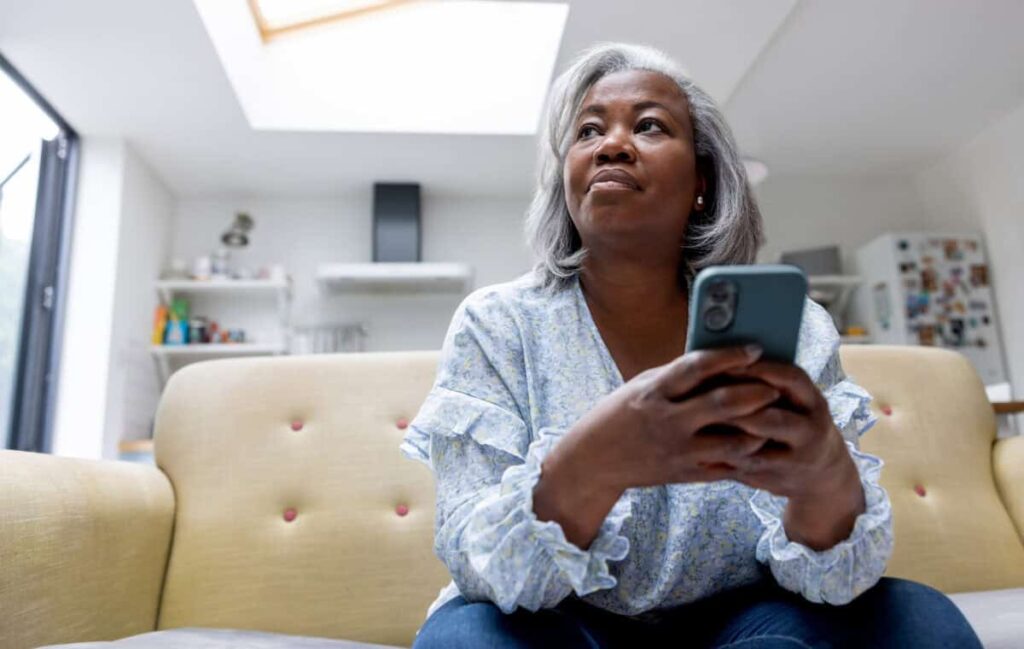 What’s the Deal With Telus’s Dividend? woman looks at iPhone